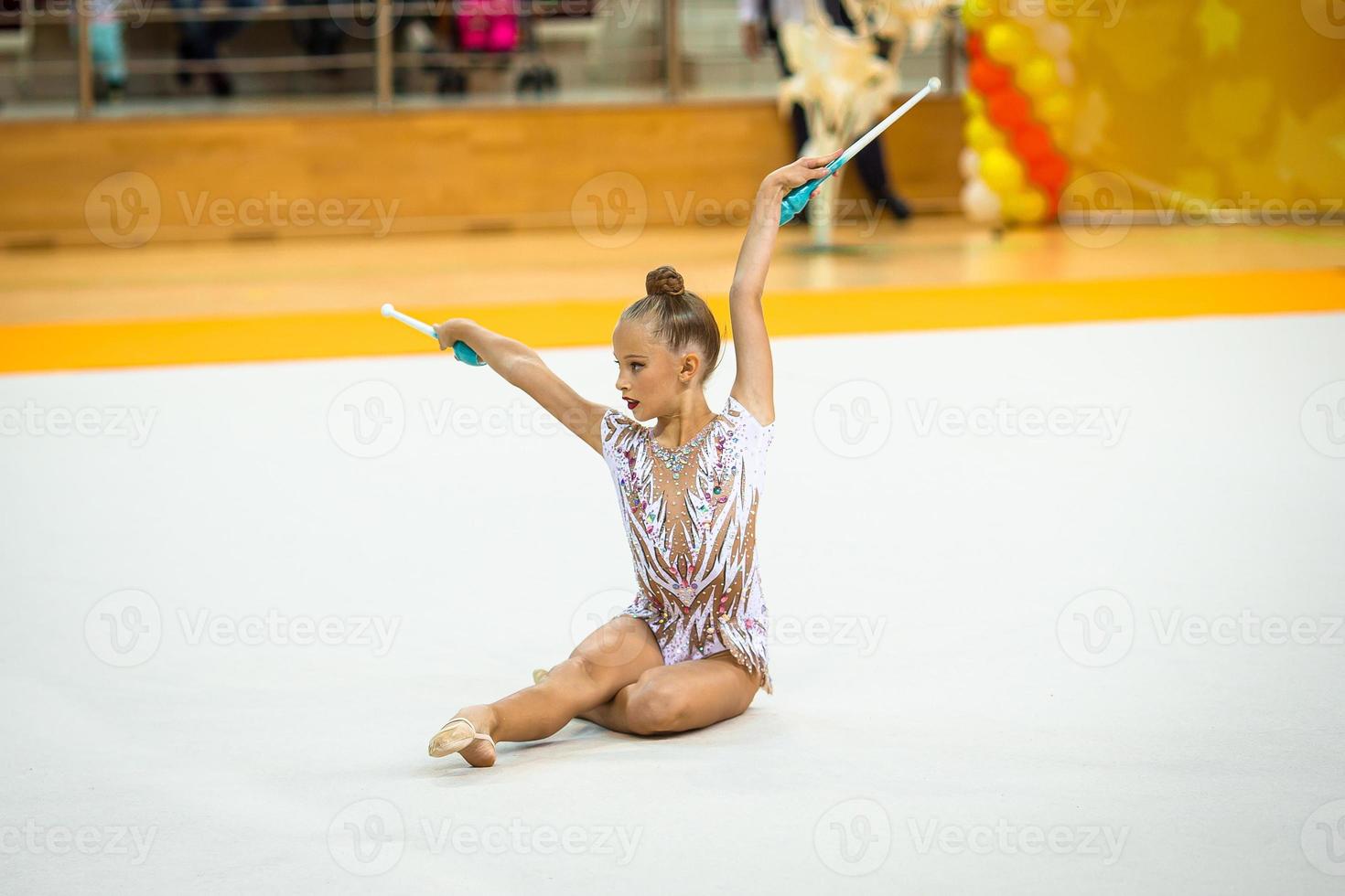 hermosa niña gimnasta activa con su actuación en la alfombra foto