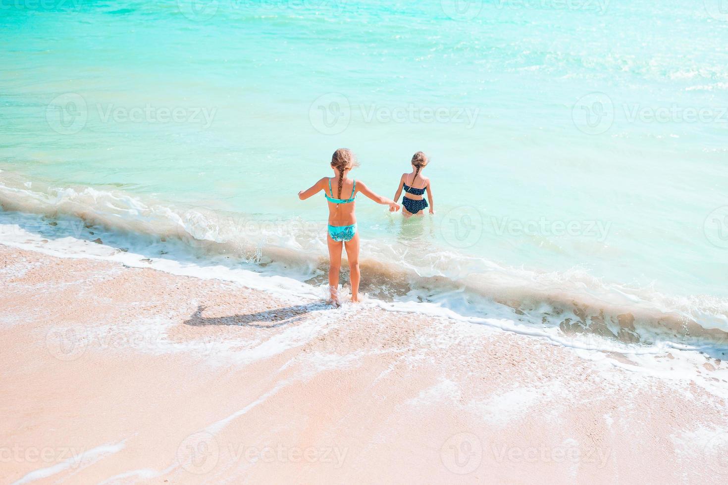 Kids have a lot of fun at tropical beach playing together photo