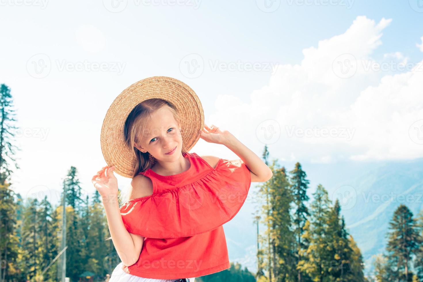 Beautiful happy little girl in mountains in the background of fog photo