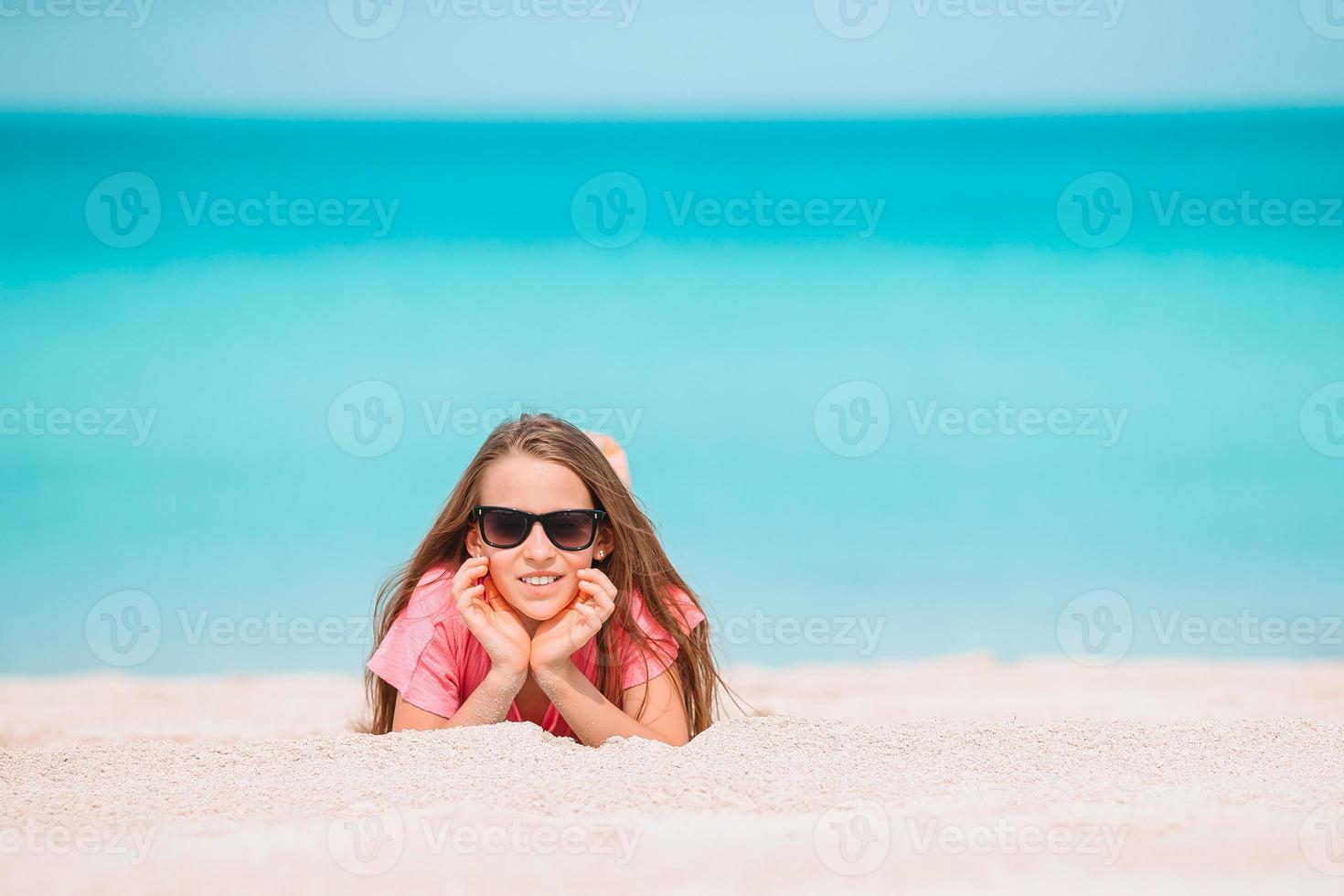 adorable niña activa en la playa durante las vacaciones de verano foto