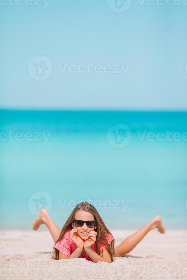 Adorable little girl have fun at tropical beach during vacation photo