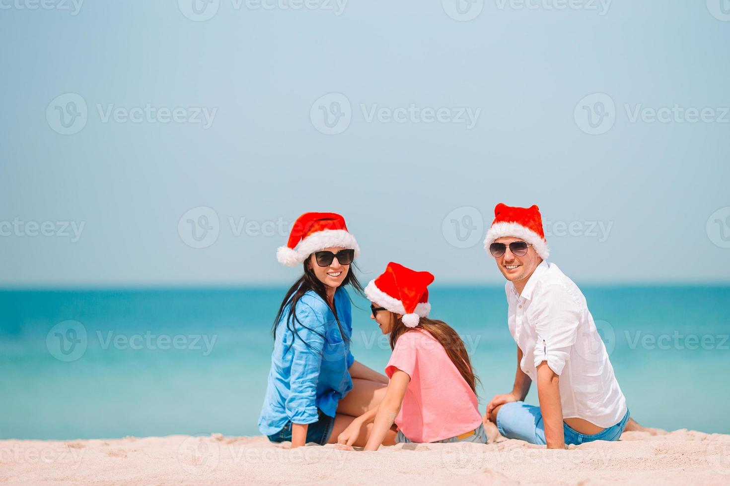 familia feliz con sombrero de santa en vacaciones de verano foto