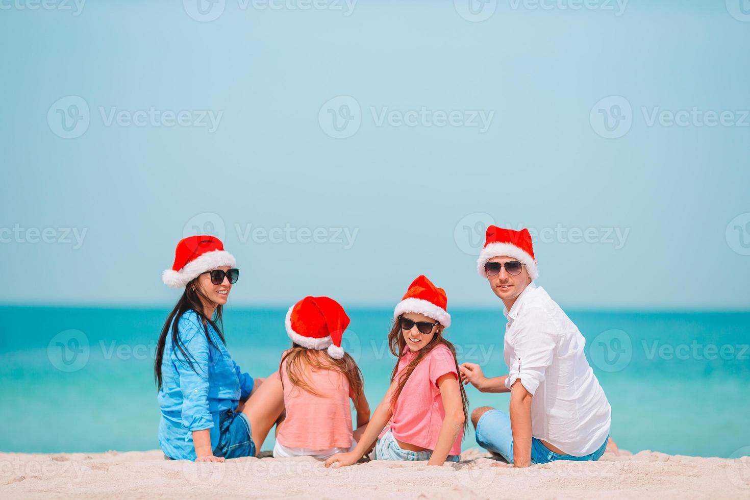 Happy family with two kids in Santa Hat on summer vacation photo