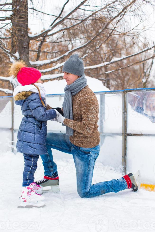 Happy family on skating rink outdoors photo