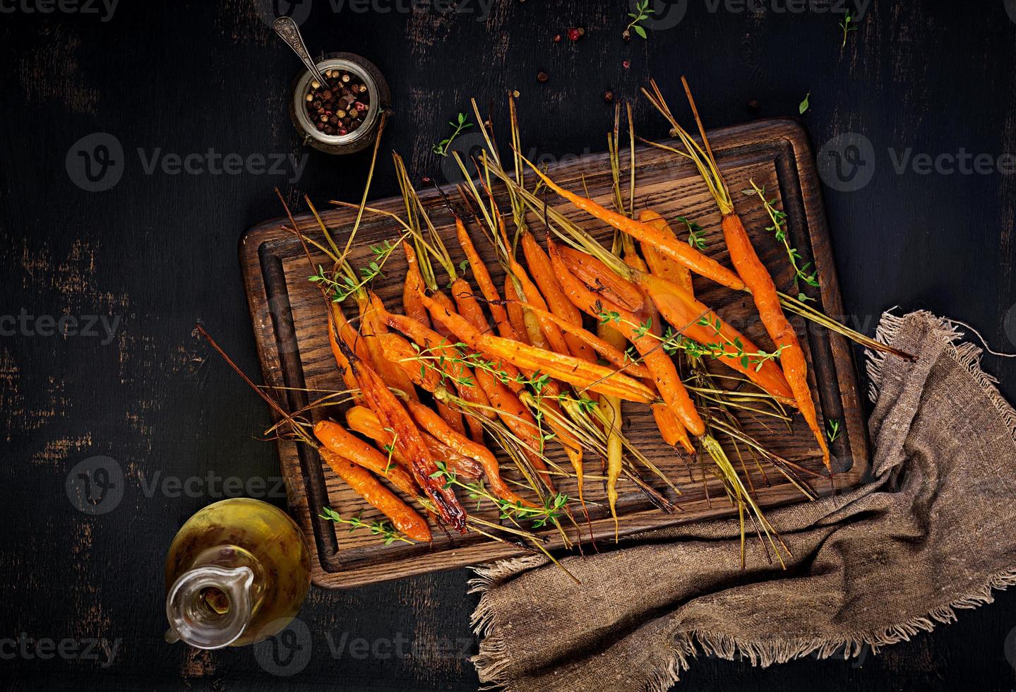 Baked organic carrots with thyme, honey and lemon. Organic vegan food. Top view photo