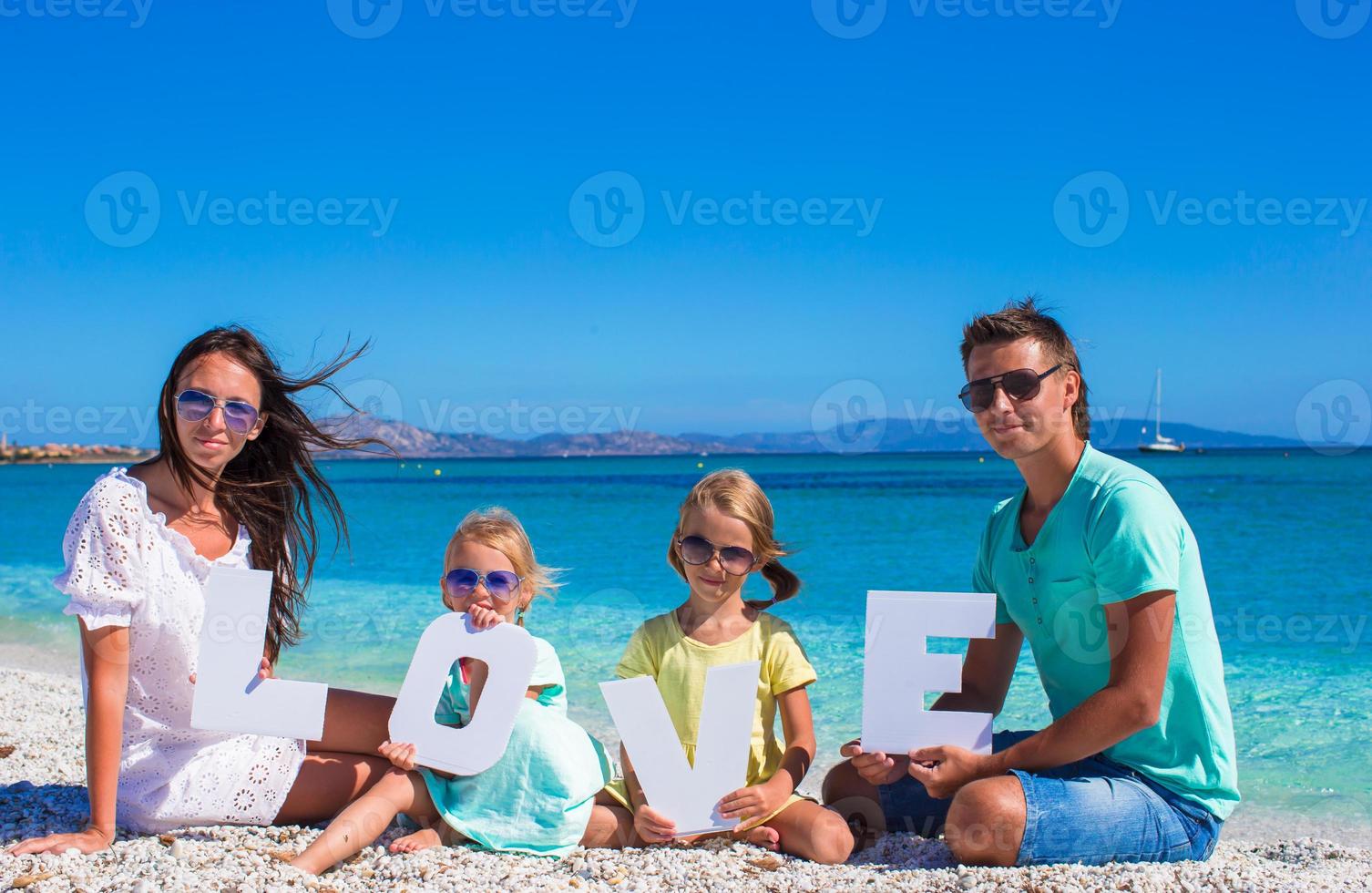Young happy family with two kids on tropical vacation photo