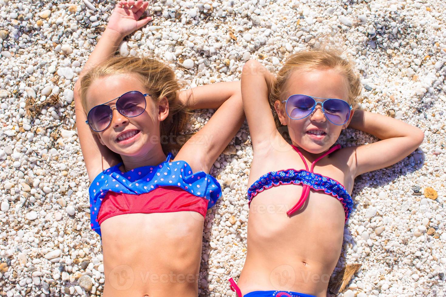 Adorable little girls at beach during summer vacation photo