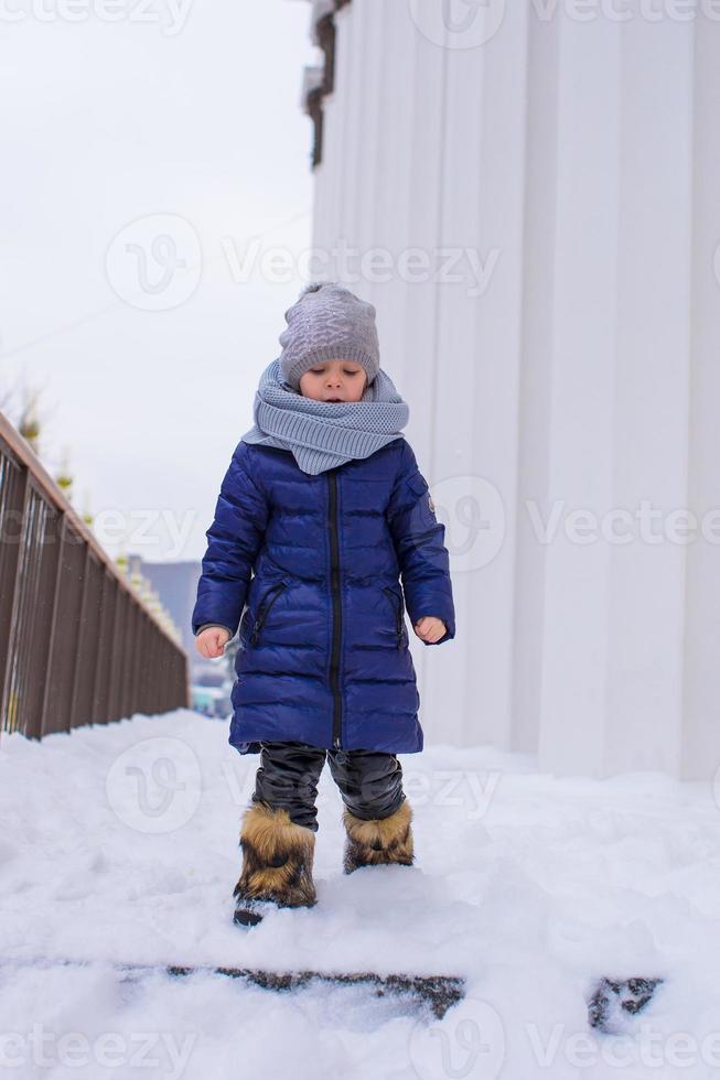 retrato de niña feliz en la nieve soleado día de invierno foto