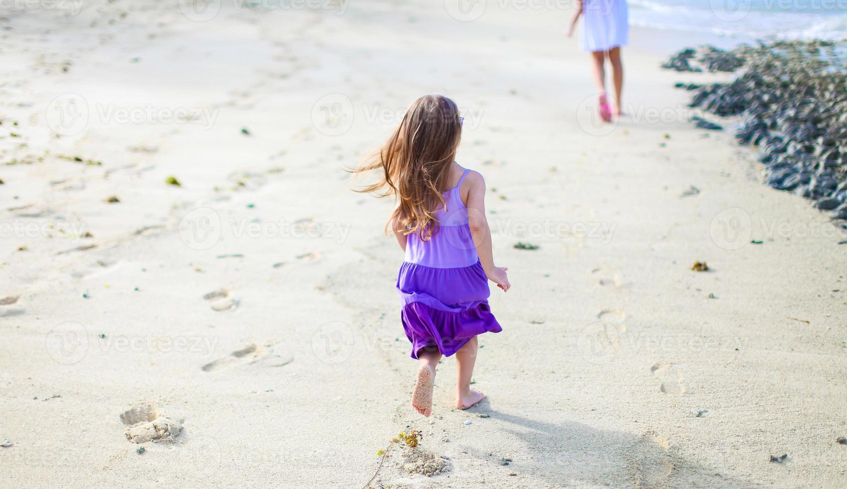 Adorable little girl having fun during tropical vacation photo