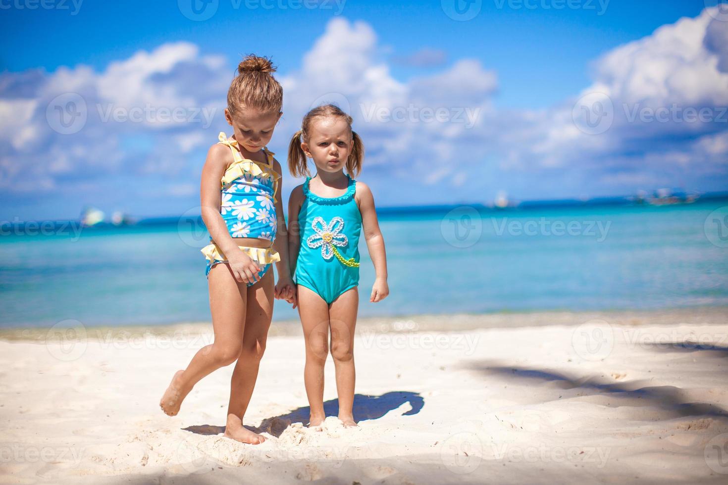 Adorable little girls at beach during summer vacation photo