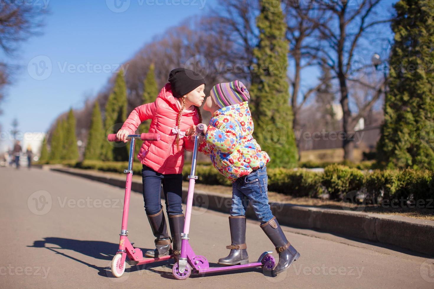 Little happy girls with scooter outdoors photo