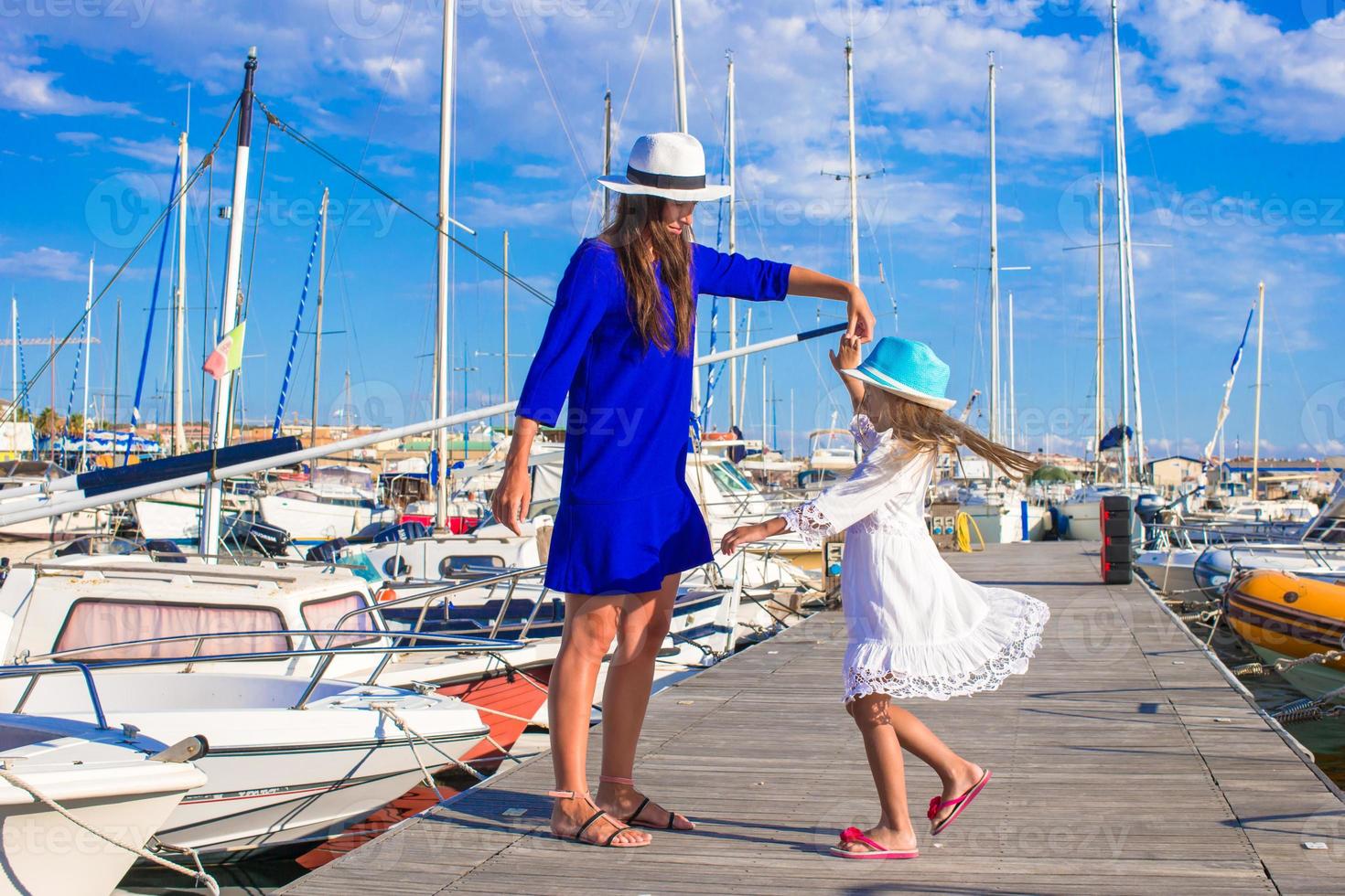 joven madre y niña en el puerto durante las vacaciones de verano foto