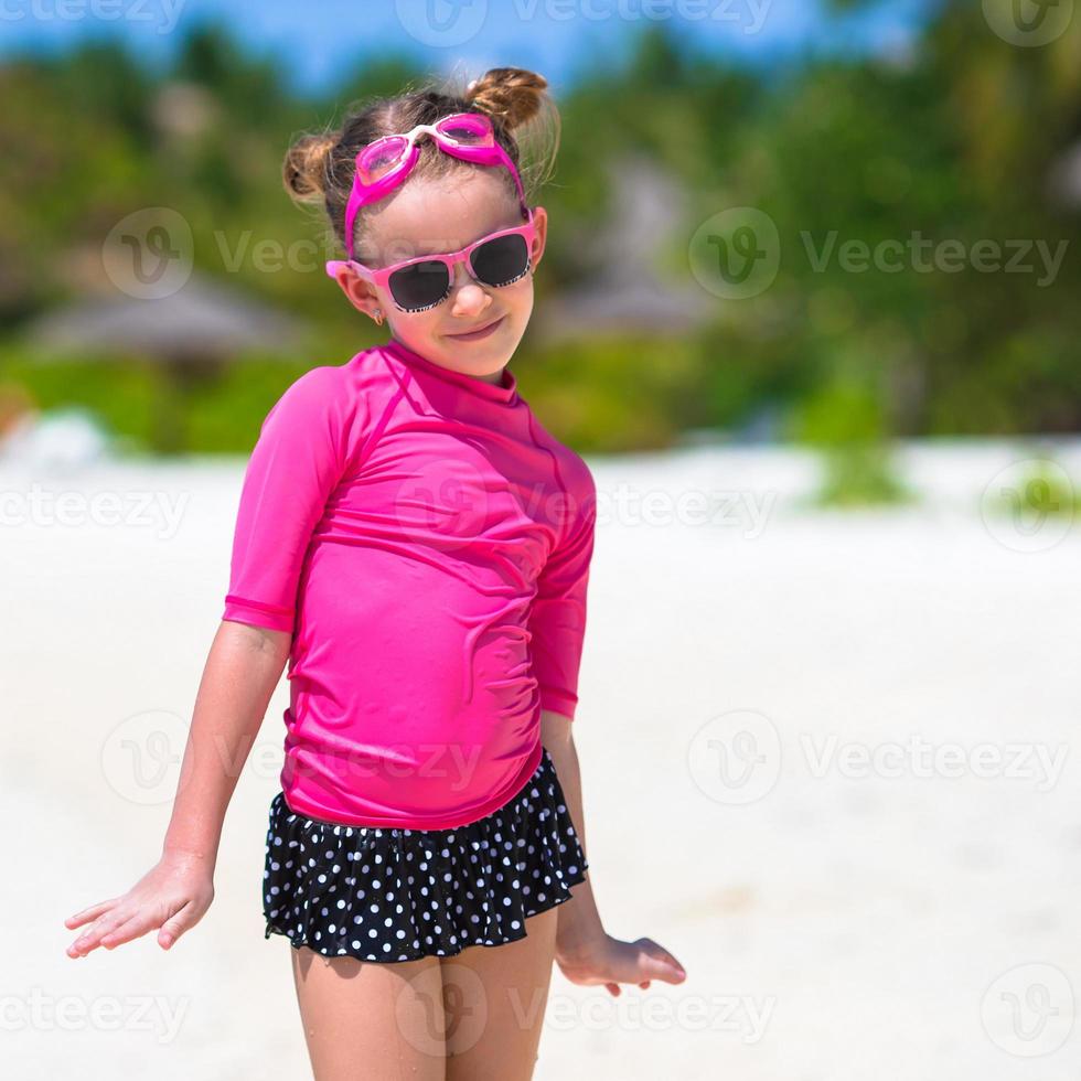 Adorable little girl at beach during summer vacation photo