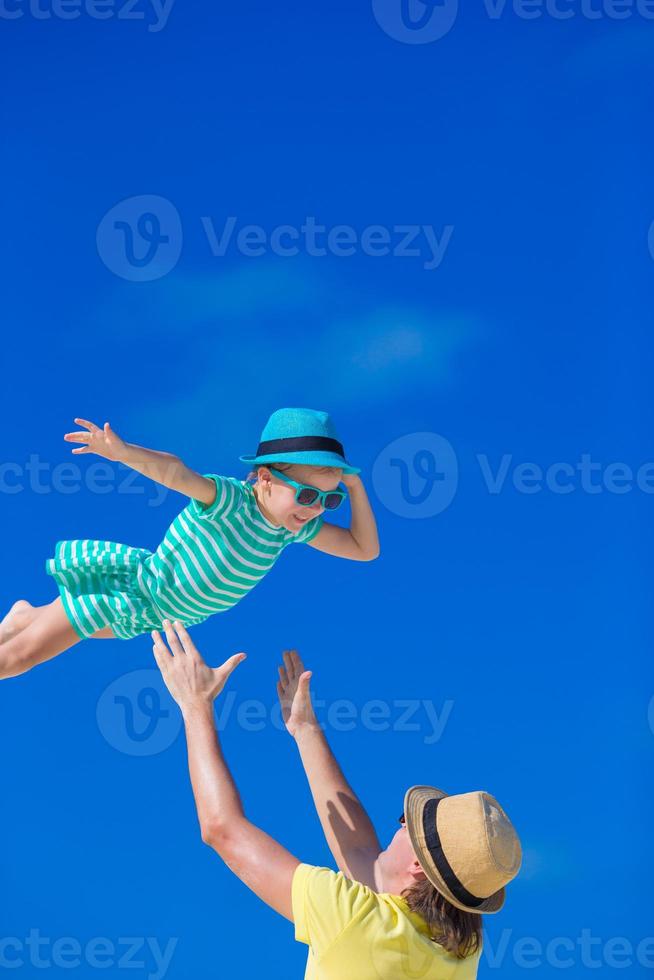 Little girl and young father during tropical beach vacation photo