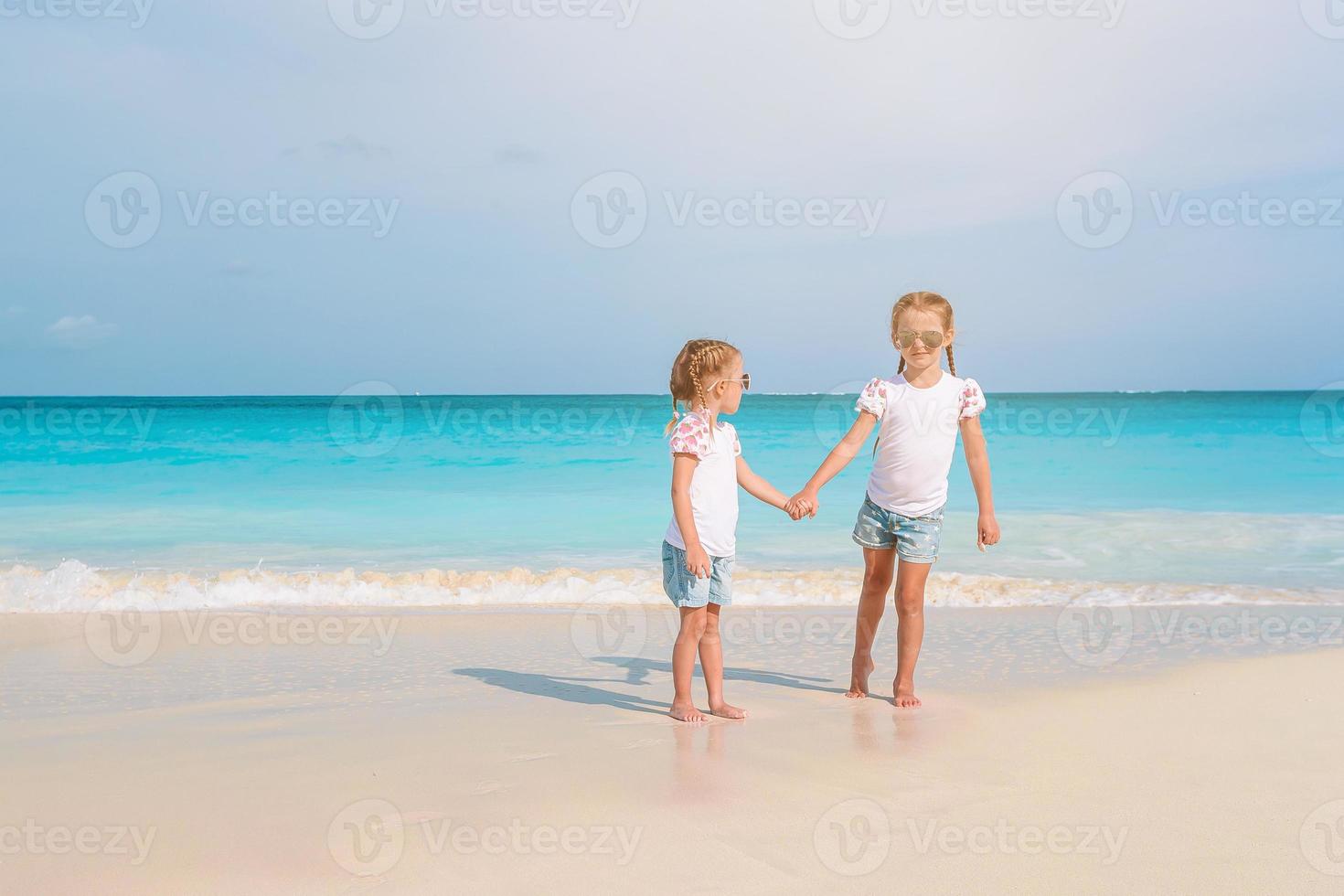 adorables niñas se divierten mucho en la playa. foto