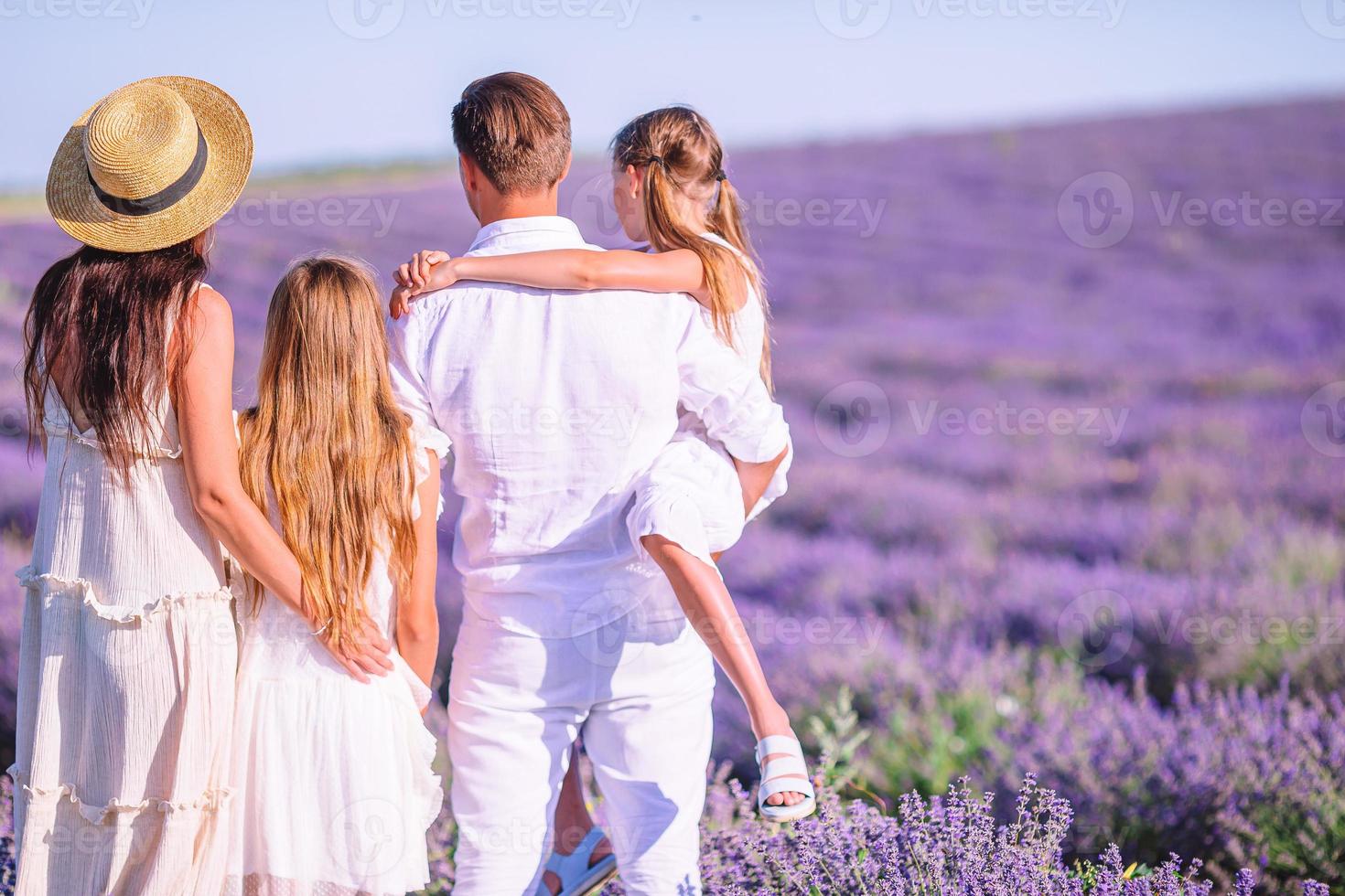 Family in lavender flowers field at sunset in white dress and hat photo