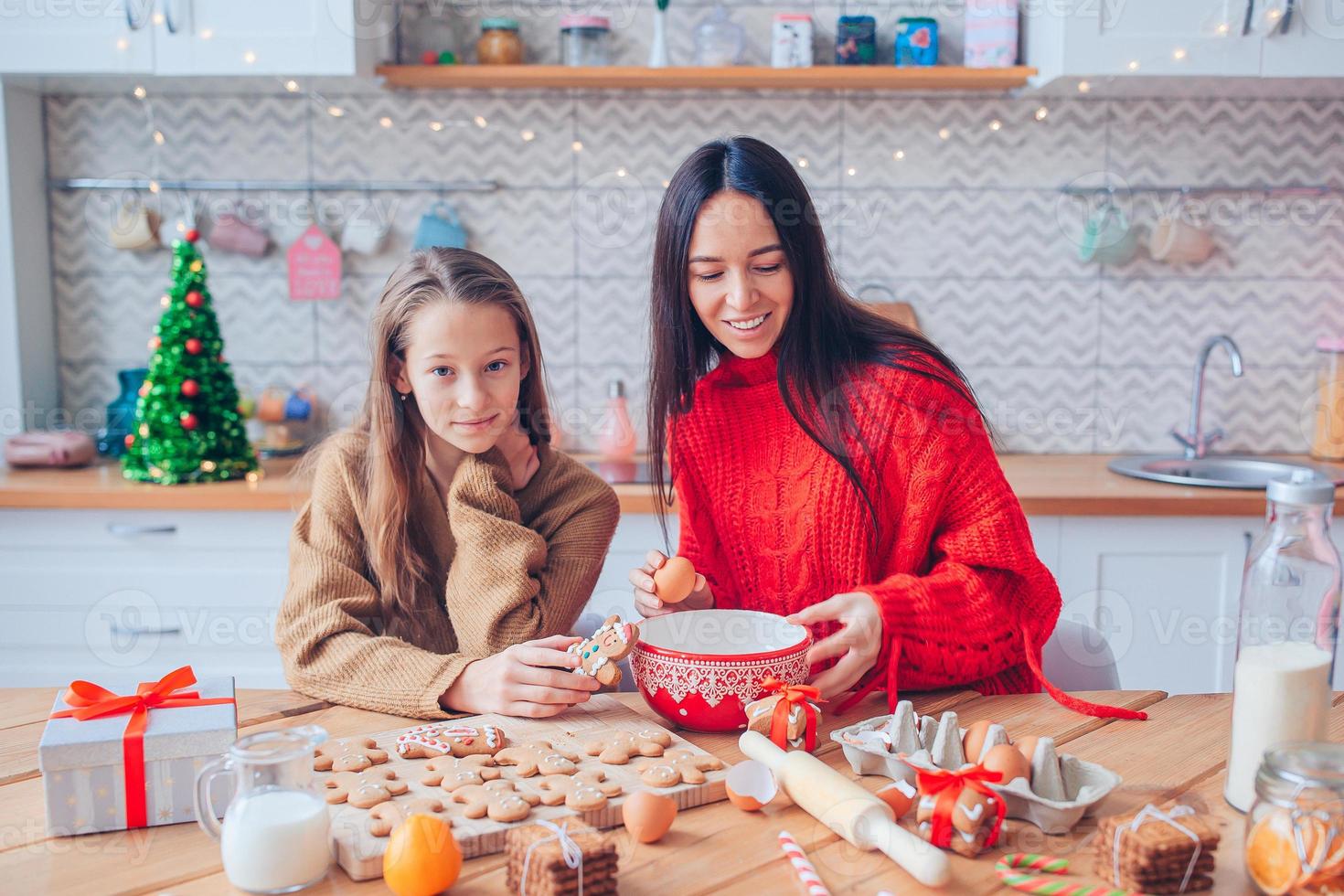 familia feliz madre e hija hornean galletas para navidad foto