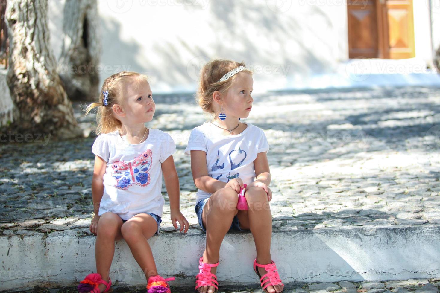 jóvenes encantadoras chicas sentadas en la calle en el antiguo pueblo griego de emporio, santorini foto