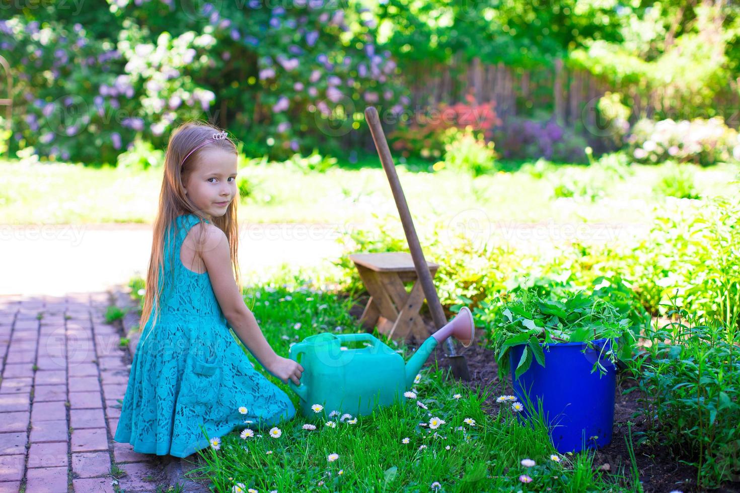 Adorable little girl with watering can outdoor photo