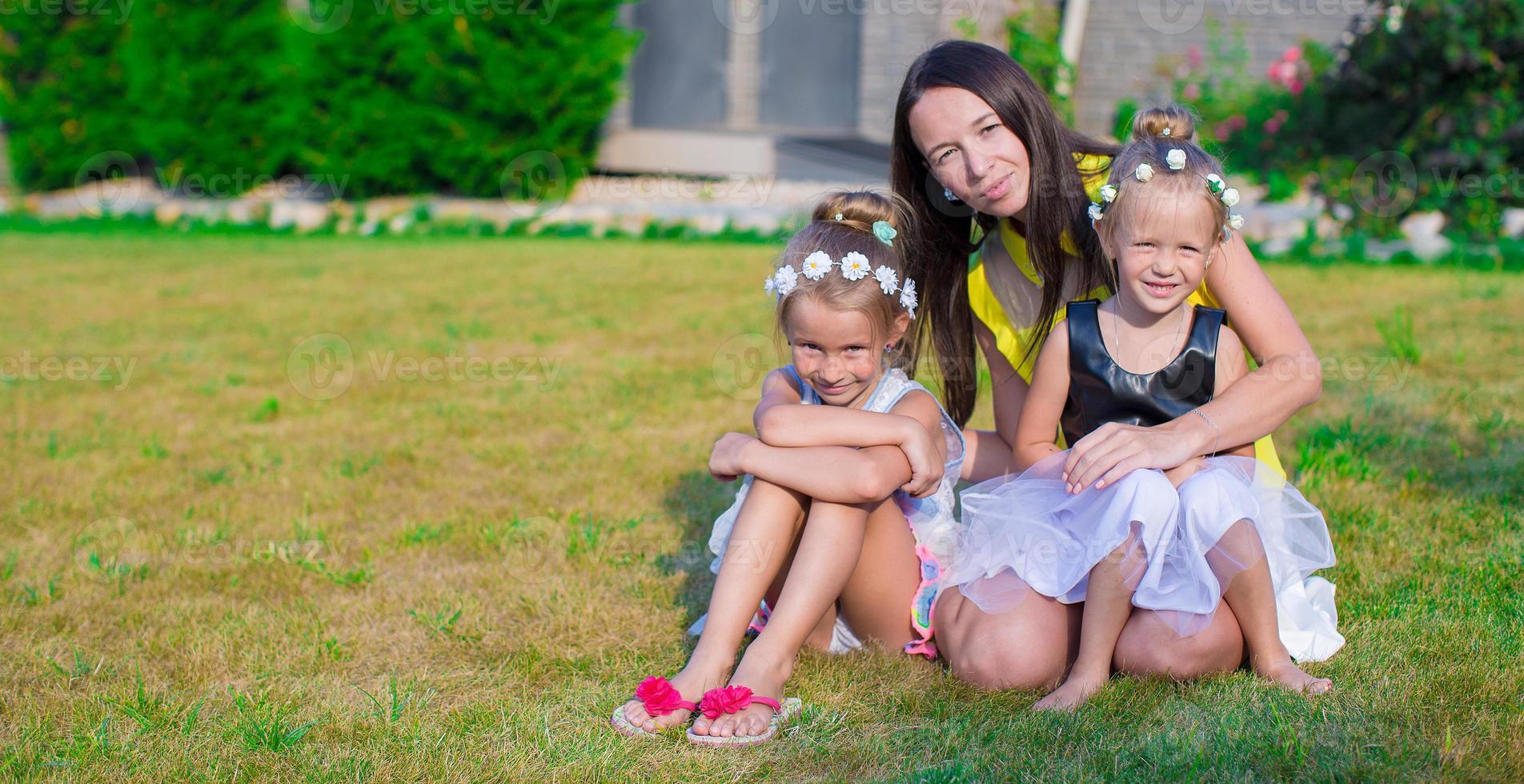 Mother and kids sitting outdoors at beautiful summer park photo