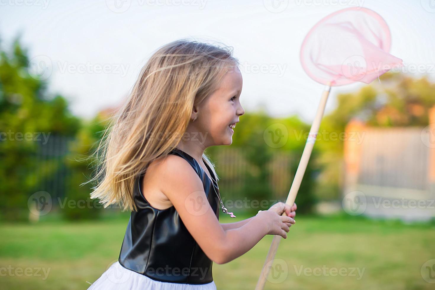 Adorable little girl catching butterflies butterfly net outdoors photo
