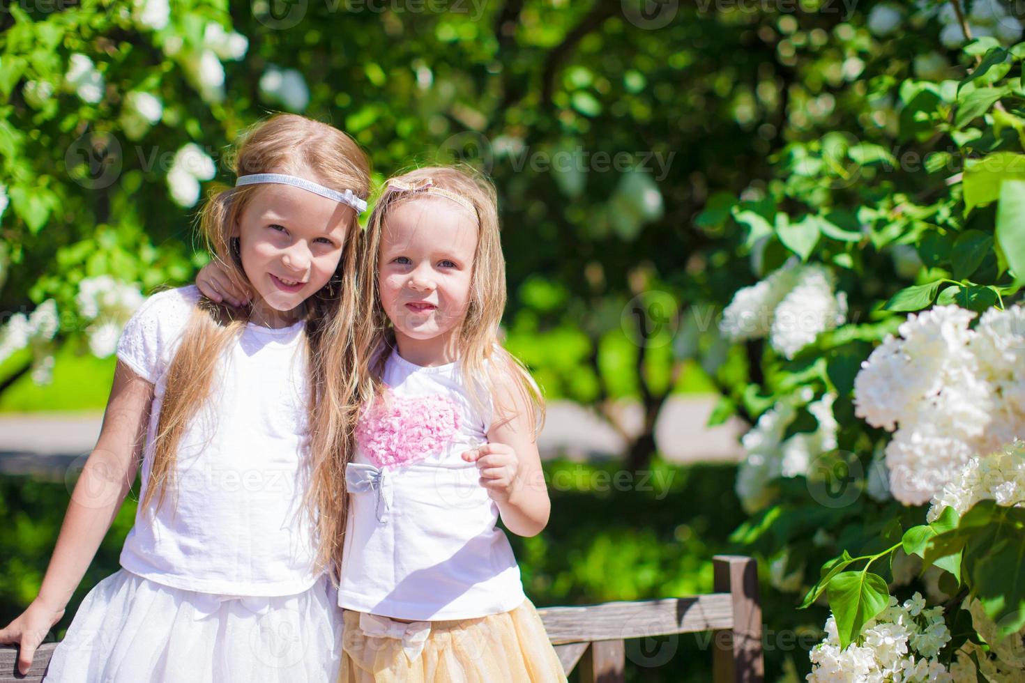 niñas adorables en el parque de árboles en flor foto