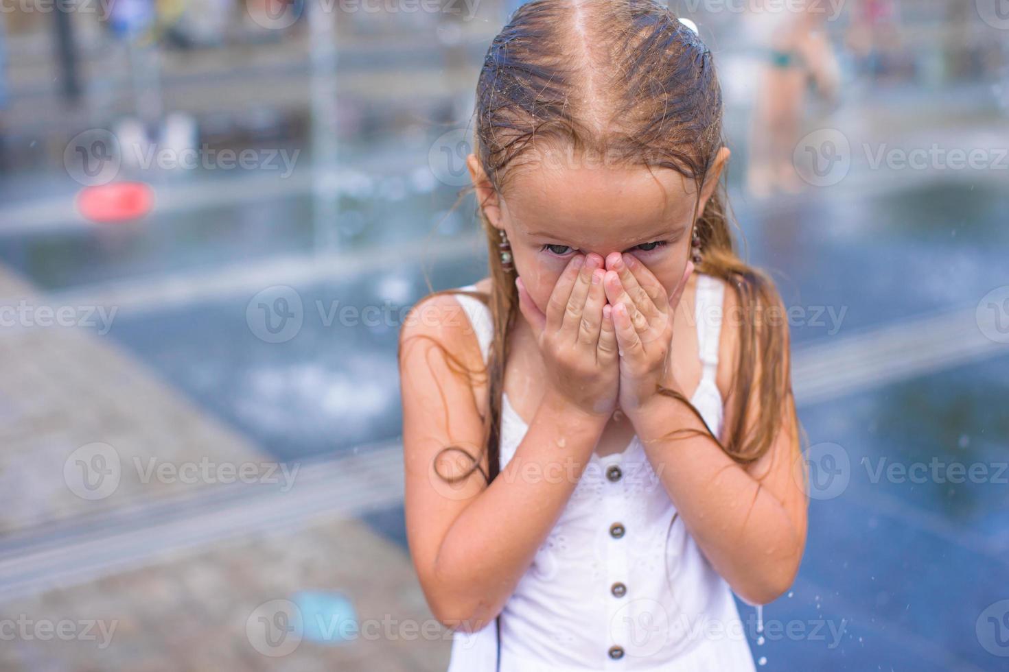 Portrait of little happy wet girl outdoors photo