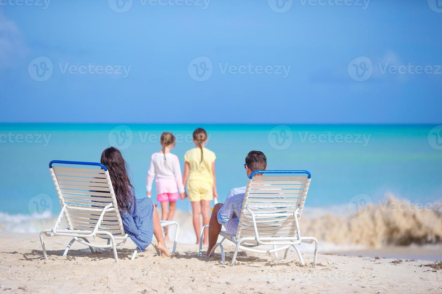 Happy beautiful family of four on the beach. photo