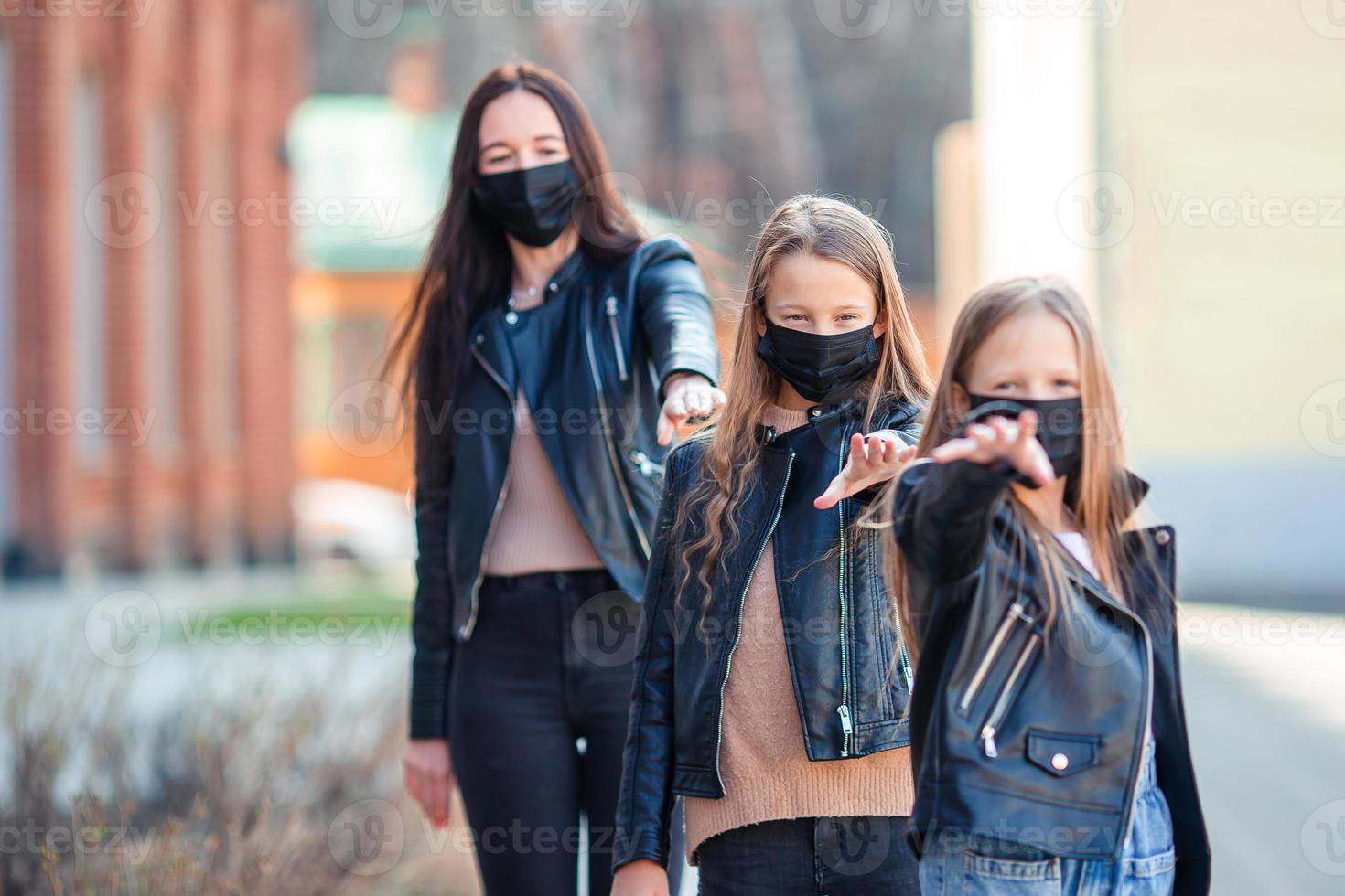 Family wearing a mask on a background of a modern building, photo