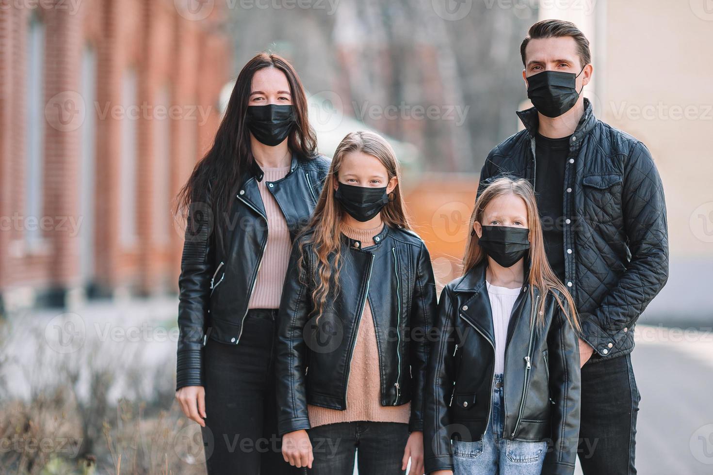 Family wearing a mask on a background of a modern building, photo