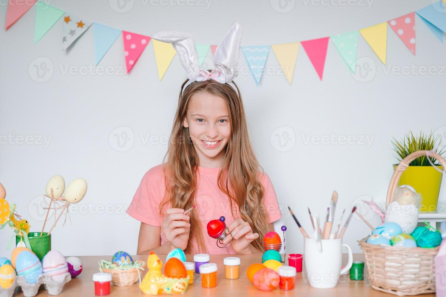 Happy easter. Beautiful little kid wearing bunny ears on Easter day. photo