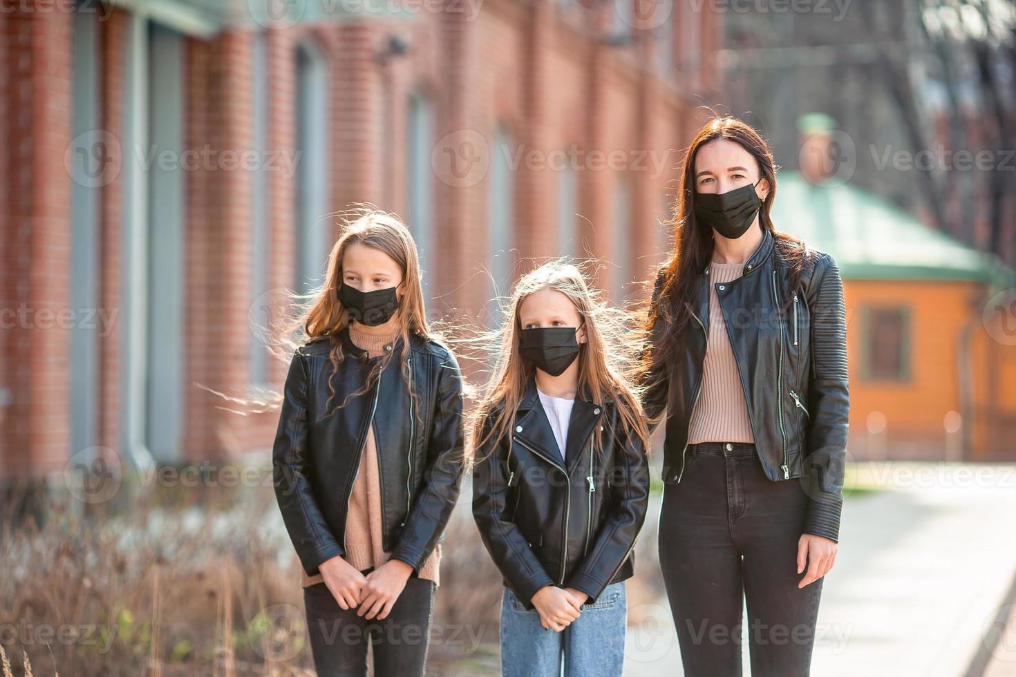 Family wearing a mask on a background of a modern building, photo