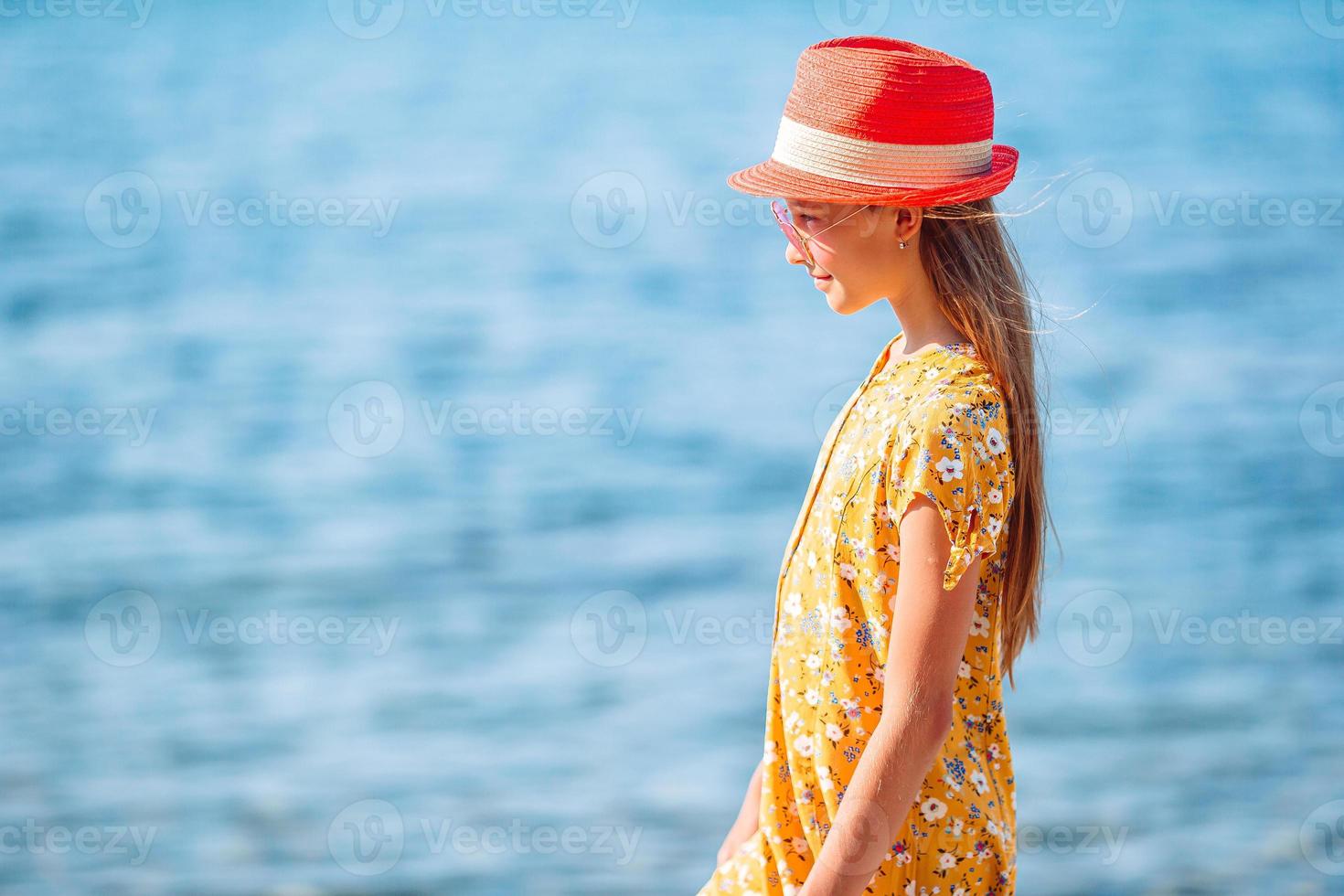 Adorable little girl at beach during summer vacation photo