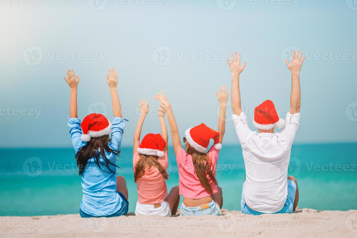 familia feliz con dos niños con sombrero de santa en vacaciones de verano foto