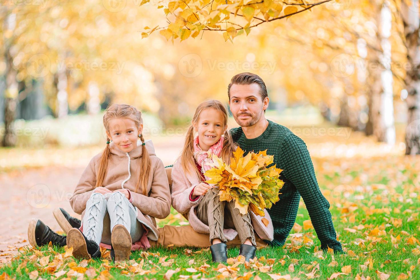 Family of dad and kids on beautiful autumn day in the park photo