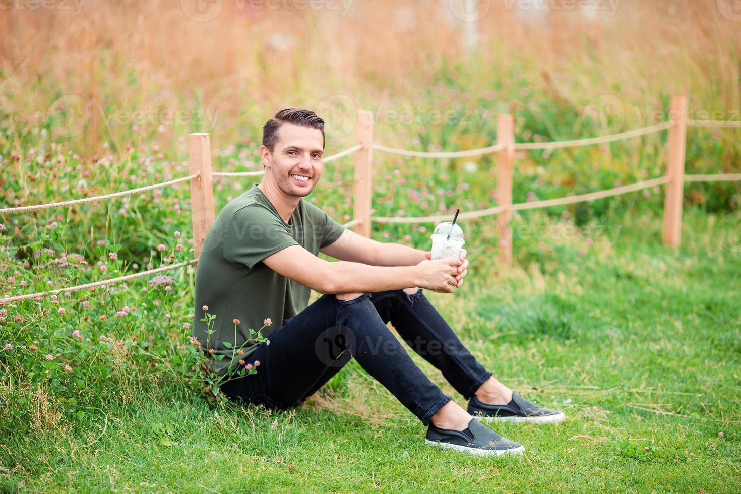Happy young urban man with book outdoors photo
