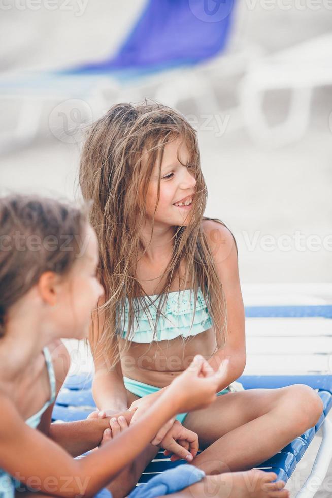 Little girls having fun at tropical beach playing together photo