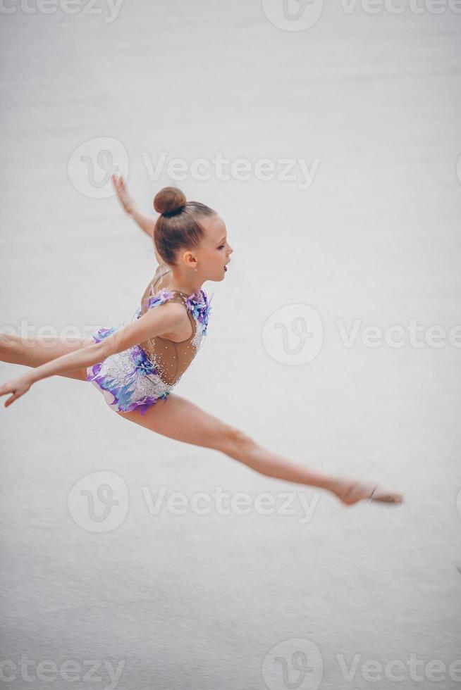 hermosa niña gimnasta activa con su actuación en la alfombra foto