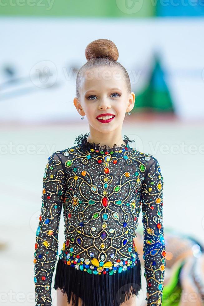 hermosa niña gimnasta activa con su actuación en la alfombra foto