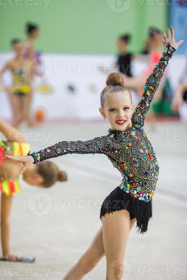 Beautiful little active gymnast girl with her performance on the carpet photo