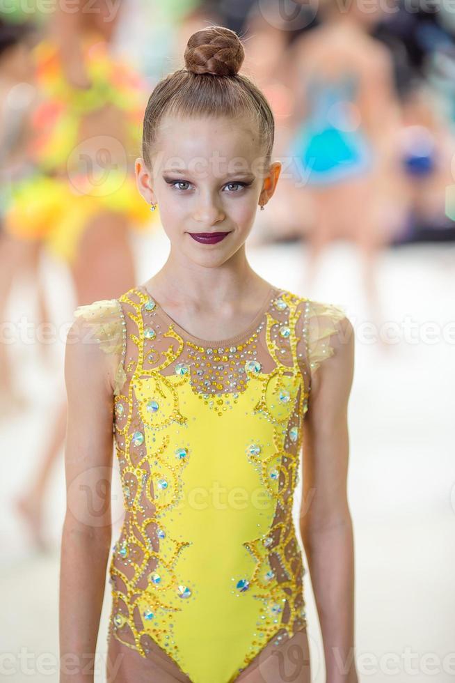 hermosa niña gimnasta activa con su actuación en la alfombra foto