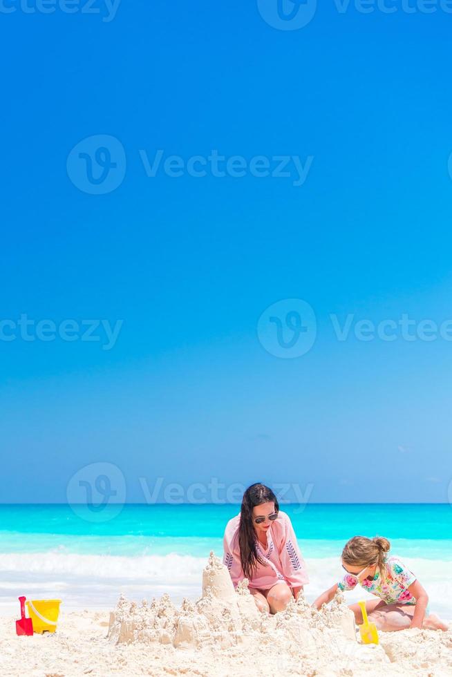 Family making sand castle at tropical white beach. photo