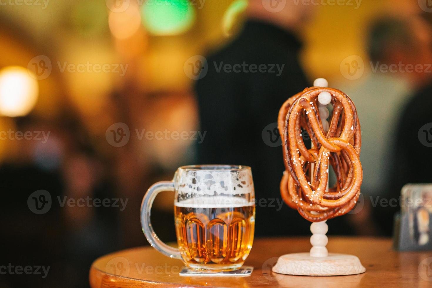 Close up salted soft pretzels and beer on wooden background. photo