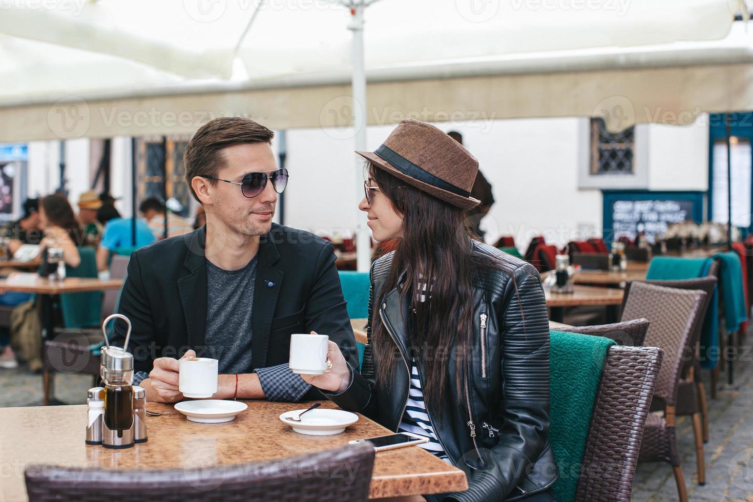 Romantic loving couple drinking coffee, having a date in the outdoor cafe photo