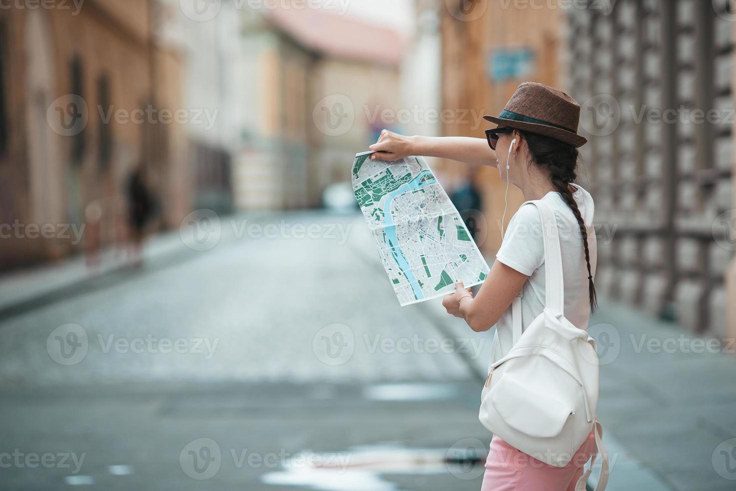 Happy young woman in hat on the street of european city. photo