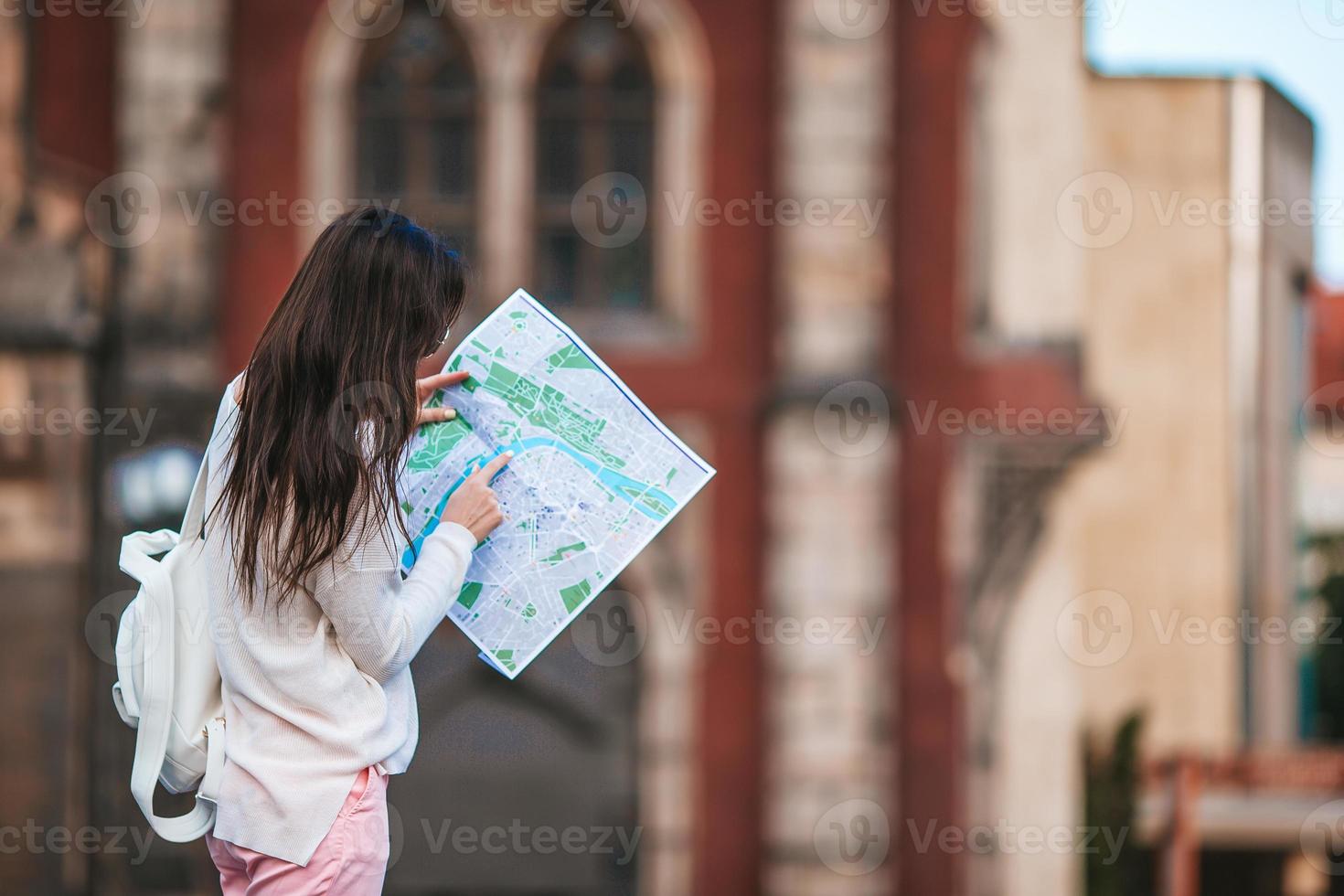 Happy young woman in hat on the street of european city. photo