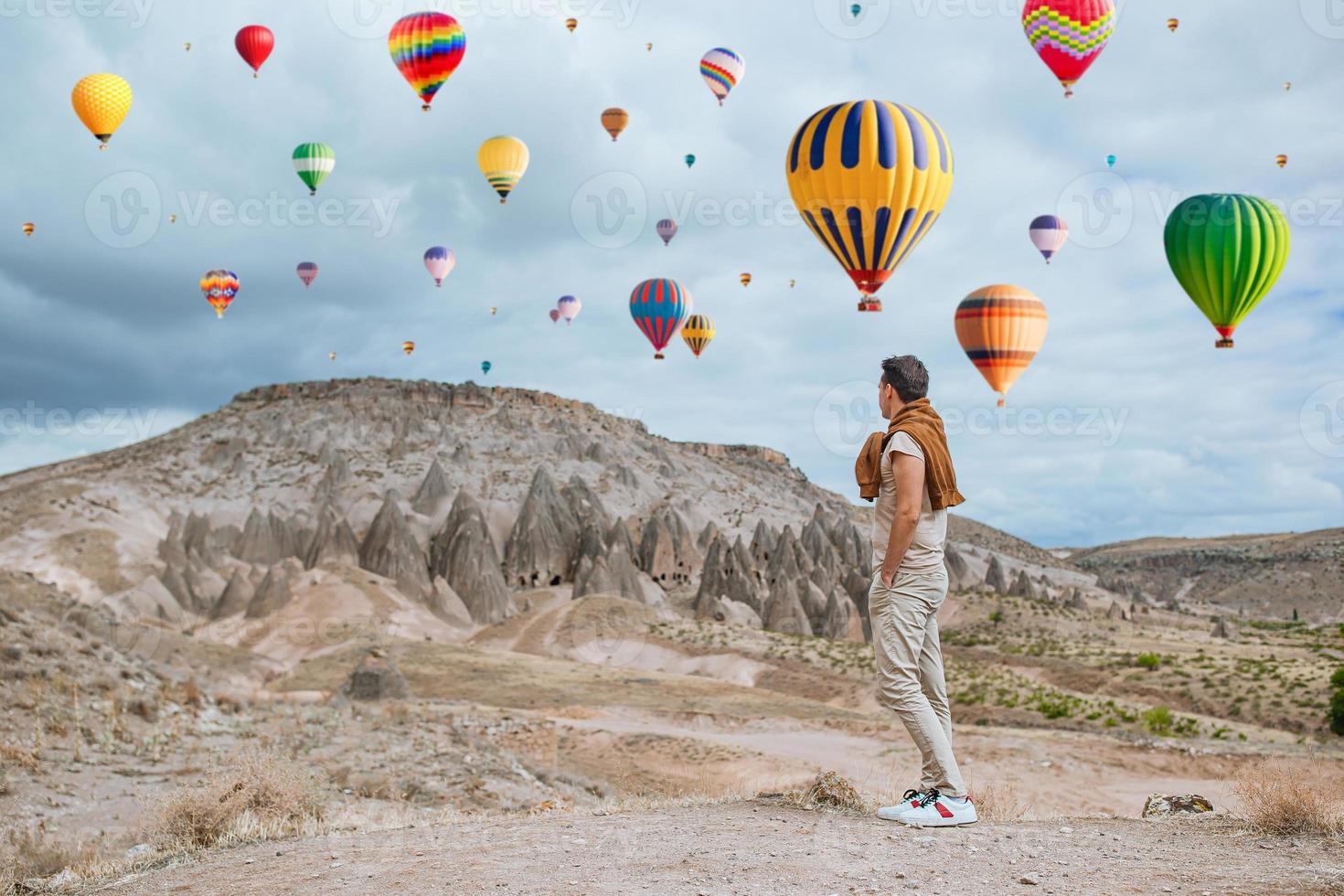 Happy young man watching hot air balloons in Cappadocia, Turkey photo