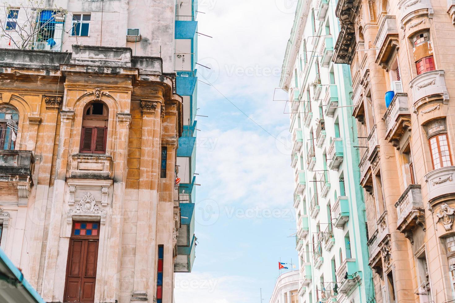 vista auténtica de una calle de la habana vieja con edificios y autos antiguos foto