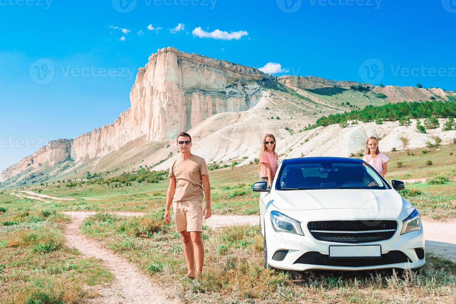 Happy family of four walking in the mountains photo
