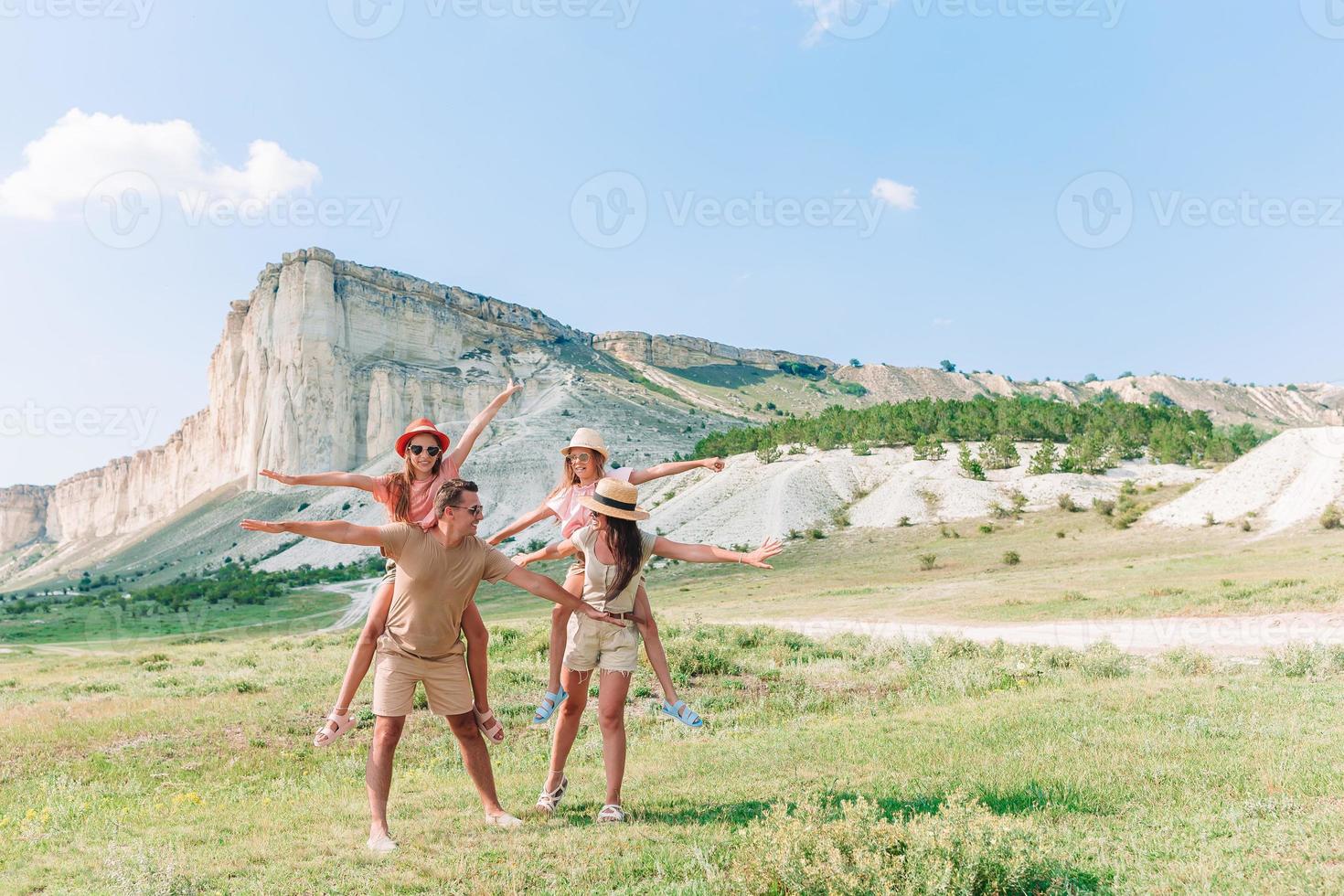 Happy family of four walking in the mountains photo